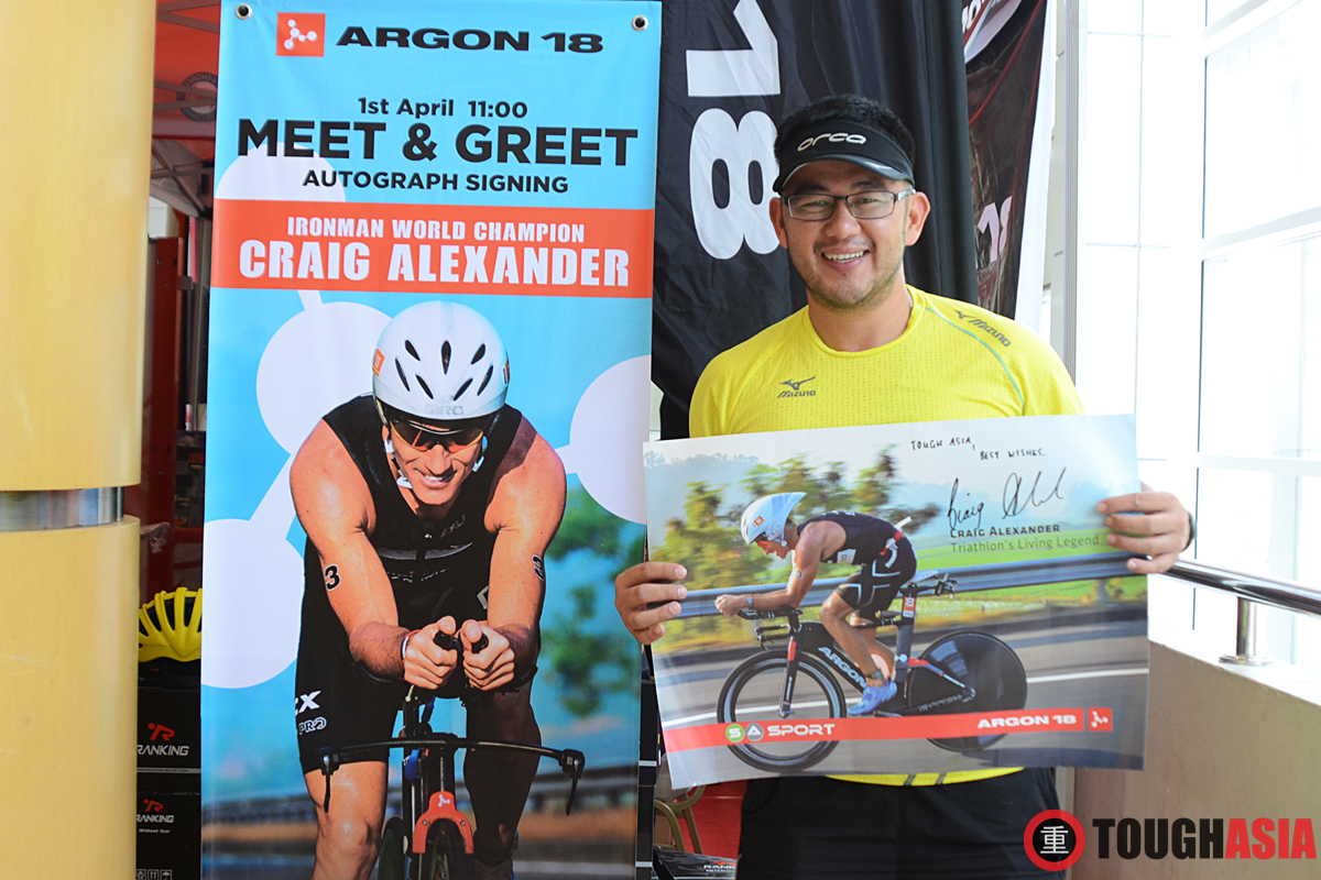 Richard Lee proudly showing Team Tough Asia's autographed poster by Triathlon Legend, Craig Alexander. 